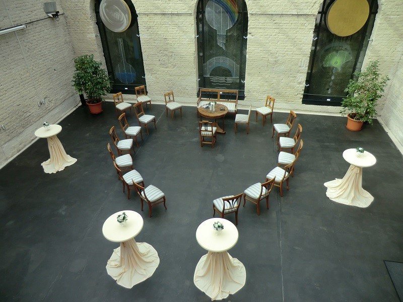 Das Foto zeigt das Atrium im Stadtmuseum von oben. Stühle sind in einem Kreis aufgestellt für eine Trauung.